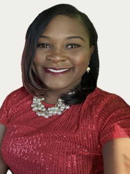 Headshot of Keonna Watson, LGBTQ+ Commissioner, smiling in a red shirt and a pearl necklace.